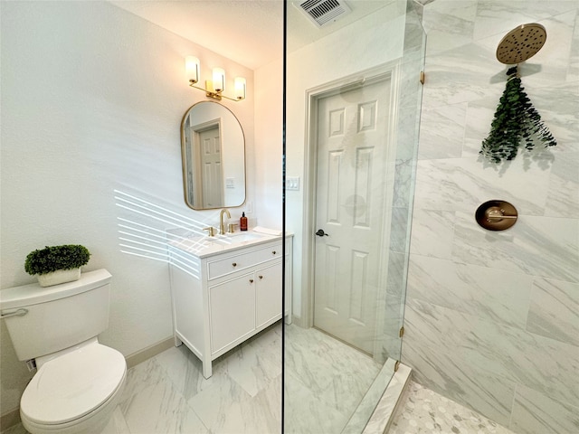 bathroom featuring toilet, vanity, and a tile shower