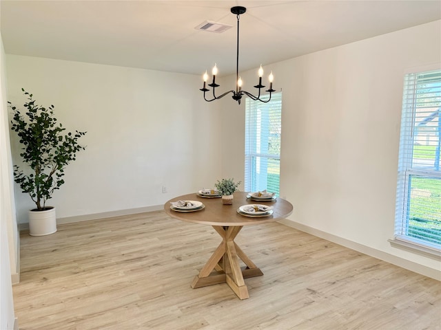 unfurnished dining area featuring light wood-type flooring and a chandelier