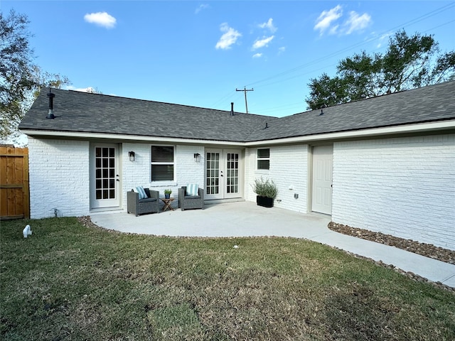 rear view of house featuring a patio area, a lawn, and french doors