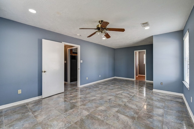 empty room featuring a textured ceiling and ceiling fan