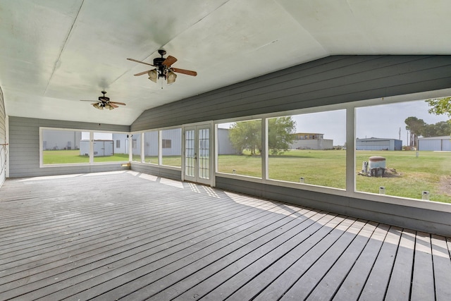 unfurnished sunroom with ceiling fan, vaulted ceiling, and a wealth of natural light