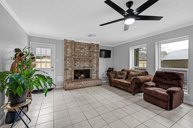 tiled living room with a fireplace, ceiling fan, ornamental molding, and plenty of natural light