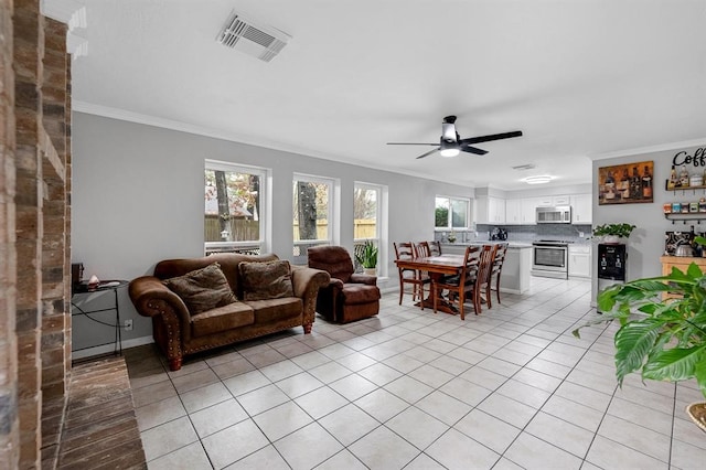 living room with light tile patterned floors, ceiling fan, crown molding, and a wealth of natural light