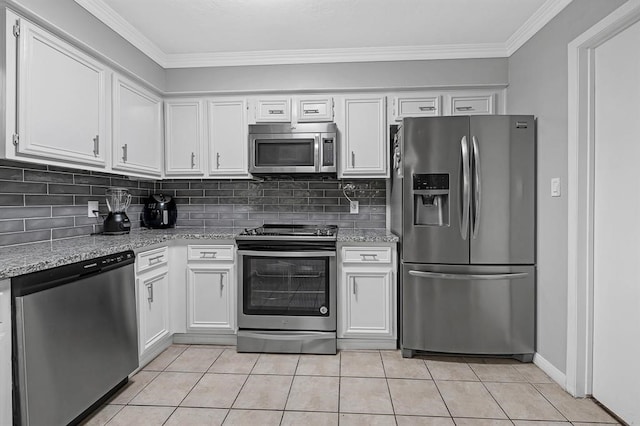 kitchen with appliances with stainless steel finishes, white cabinets, light tile patterned flooring, and light stone countertops