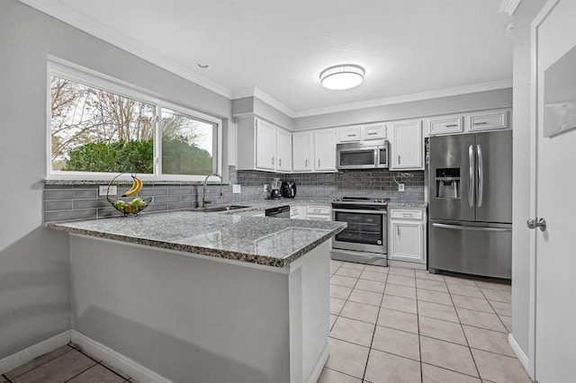 kitchen featuring kitchen peninsula, light stone countertops, white cabinetry, appliances with stainless steel finishes, and sink