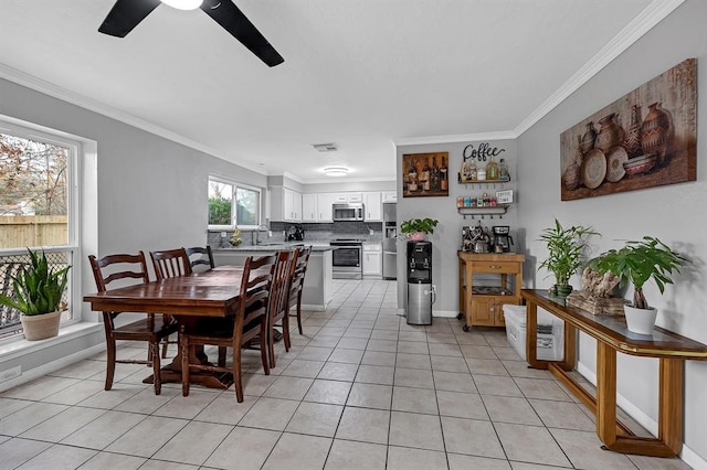 tiled dining space with ceiling fan, ornamental molding, and sink