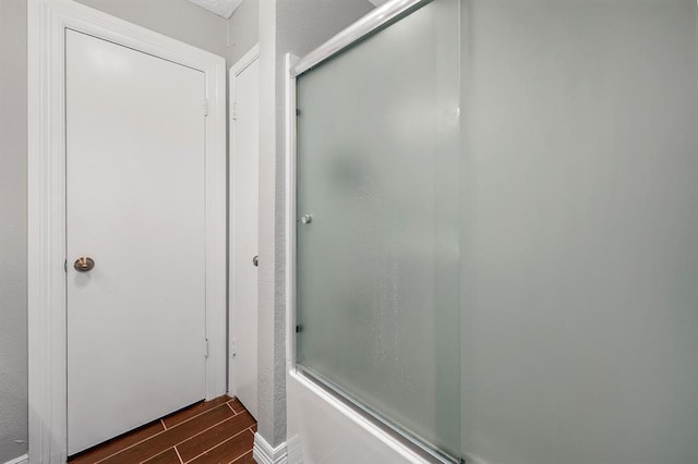 bathroom featuring bath / shower combo with glass door