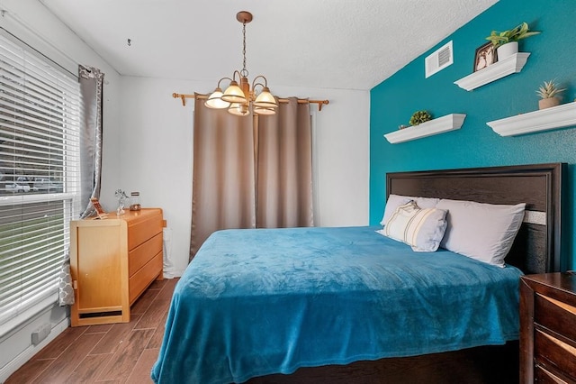 bedroom with a textured ceiling and a notable chandelier