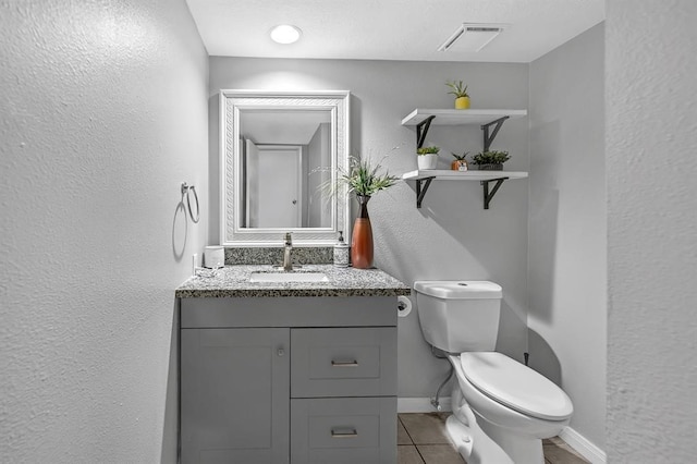 bathroom with toilet, tile patterned flooring, and vanity