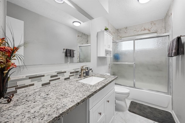 full bathroom featuring a textured ceiling, shower / bath combination with glass door, tasteful backsplash, toilet, and vanity