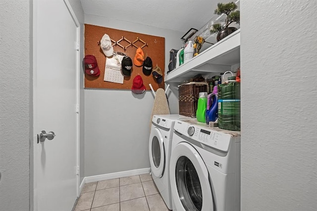 clothes washing area featuring light tile patterned flooring and separate washer and dryer