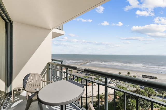 balcony with a water view and a view of the beach