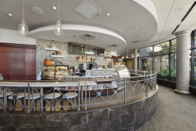 bar featuring decorative columns and carpet floors