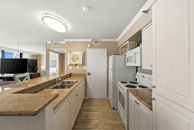 kitchen with a kitchen breakfast bar, kitchen peninsula, white appliances, white cabinetry, and light hardwood / wood-style floors