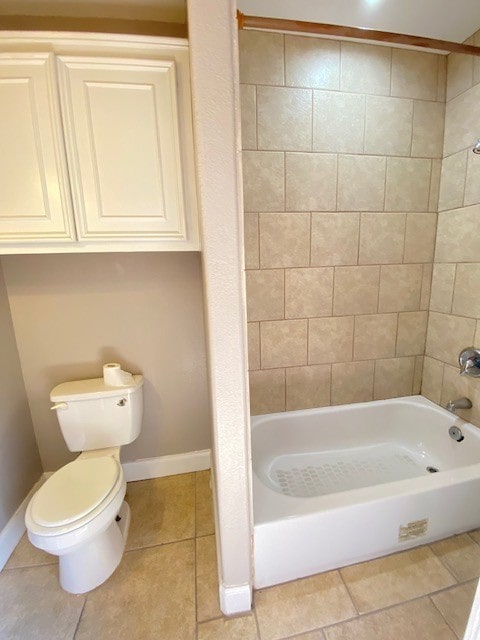 bathroom with toilet, tile patterned flooring, and tiled shower / bath