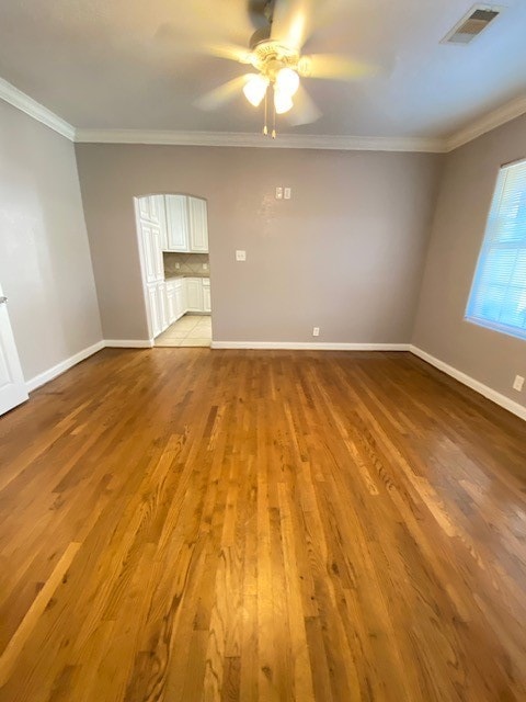 spare room featuring light hardwood / wood-style floors, ornamental molding, and ceiling fan