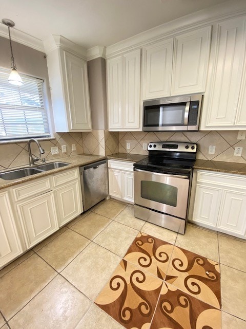 kitchen featuring sink, white cabinets, hanging light fixtures, and stainless steel appliances