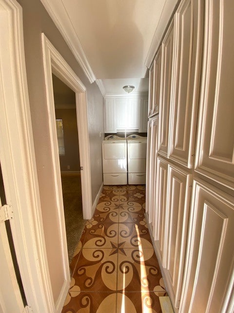 corridor featuring ornamental molding, light tile patterned flooring, and separate washer and dryer