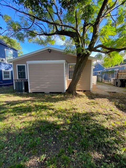 exterior space with an outbuilding, cooling unit, and a lawn