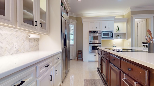 kitchen with ornamental molding, decorative backsplash, white cabinetry, and built in appliances