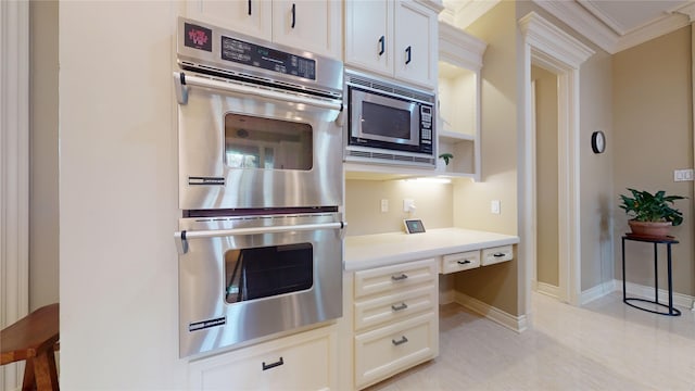 kitchen with ornamental molding, white cabinets, and stainless steel appliances