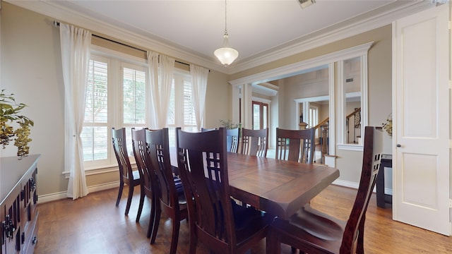 dining area featuring ornamental molding, hardwood / wood-style flooring, and plenty of natural light