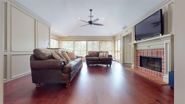 living room featuring lofted ceiling, ceiling fan, a fireplace, and dark hardwood / wood-style flooring