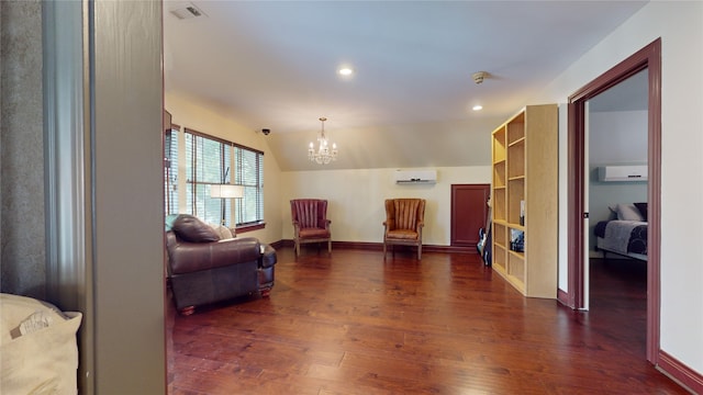 sitting room featuring a wall unit AC, dark wood-type flooring, vaulted ceiling, and a notable chandelier