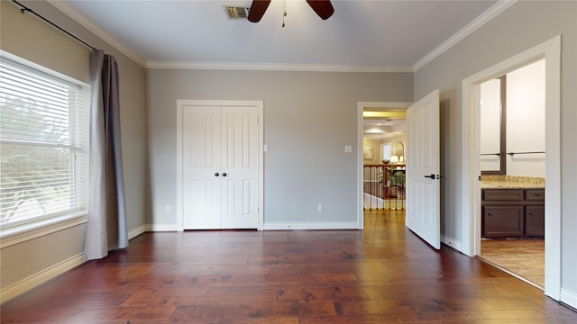 unfurnished bedroom with multiple windows, dark wood-type flooring, crown molding, and ceiling fan