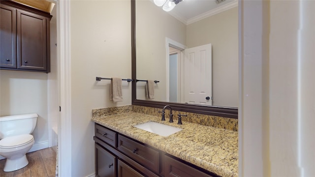 bathroom with a washtub, hardwood / wood-style floors, toilet, vanity, and ornamental molding