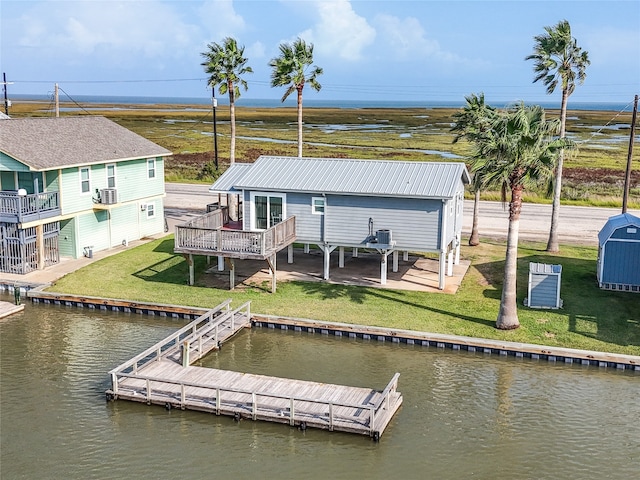 view of dock with a deck with water view, a yard, and cooling unit