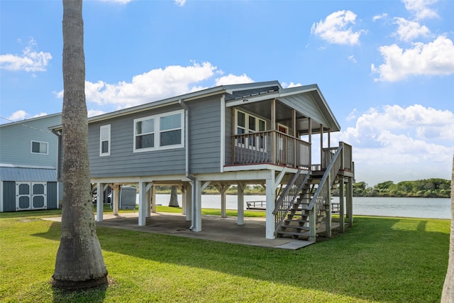 back of house with a patio area, a yard, a water view, and a sunroom