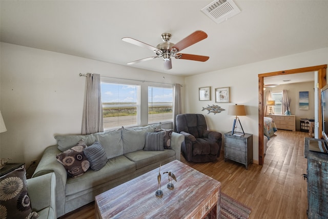 living room featuring light hardwood / wood-style flooring and ceiling fan