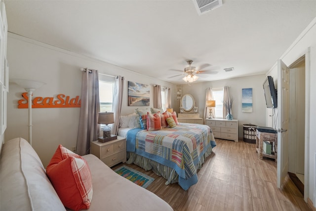 bedroom with ornamental molding, light wood-type flooring, and ceiling fan