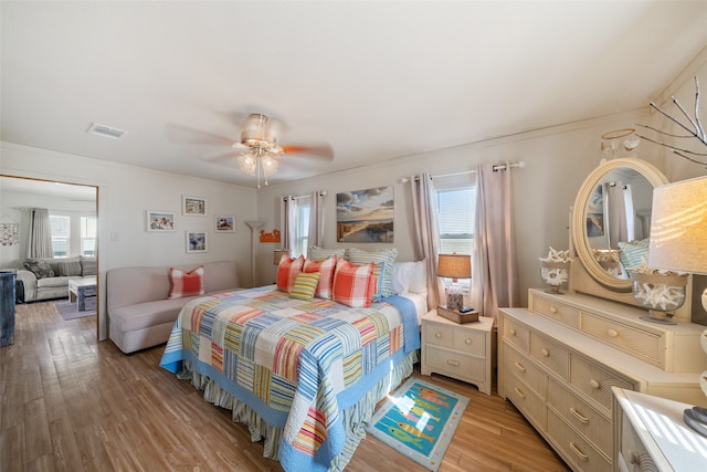 bedroom featuring light hardwood / wood-style floors, multiple windows, and ceiling fan