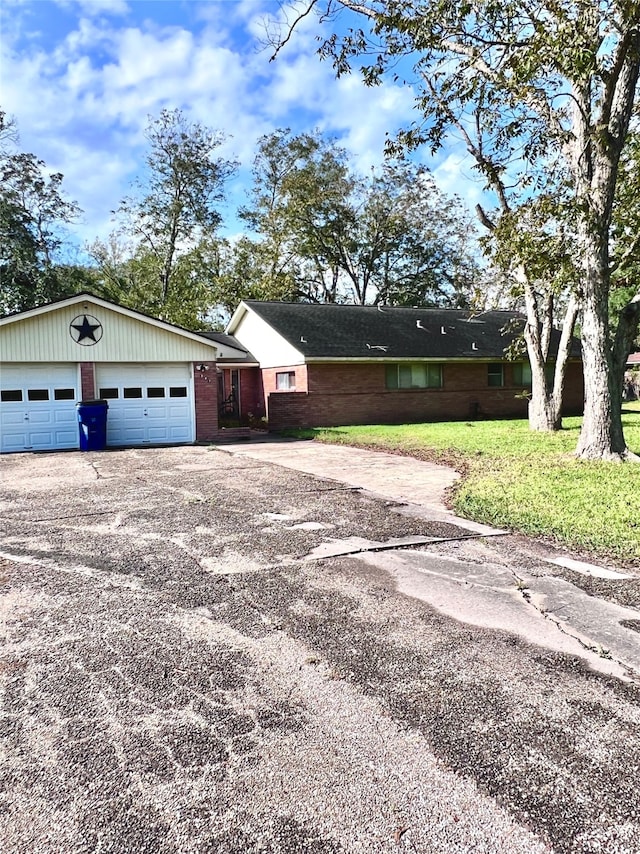 single story home featuring a garage and a front lawn