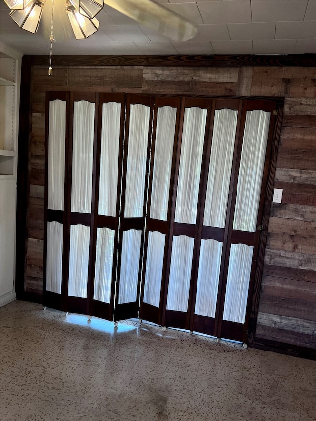 empty room featuring wooden walls and a healthy amount of sunlight