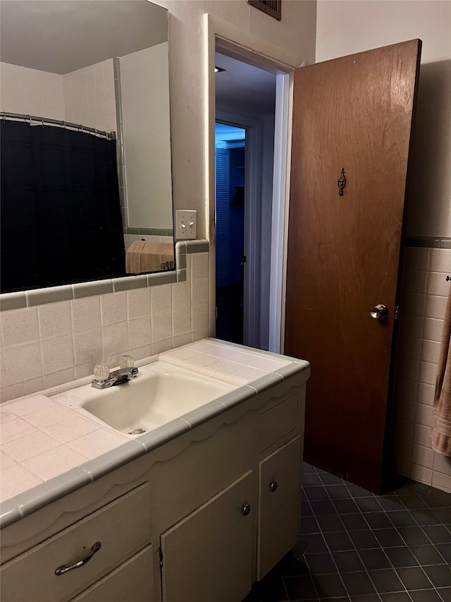 bathroom with tile patterned floors, decorative backsplash, vanity, and tile walls