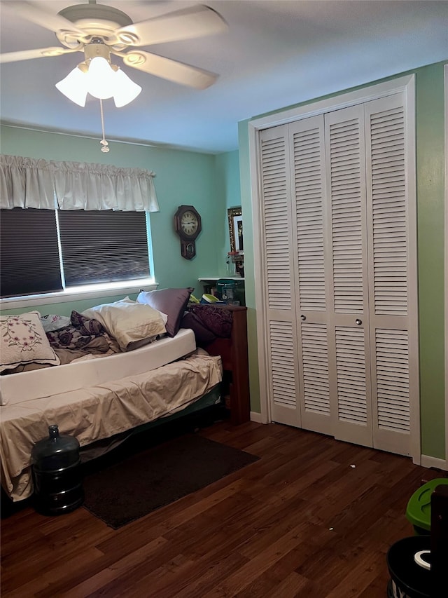 bedroom with a closet, dark hardwood / wood-style floors, and ceiling fan