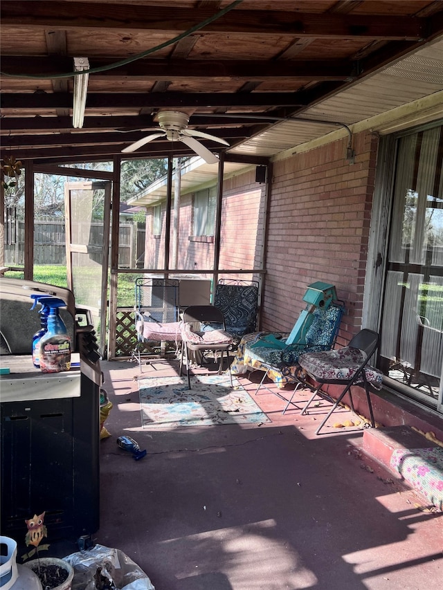 unfurnished sunroom with ceiling fan and vaulted ceiling