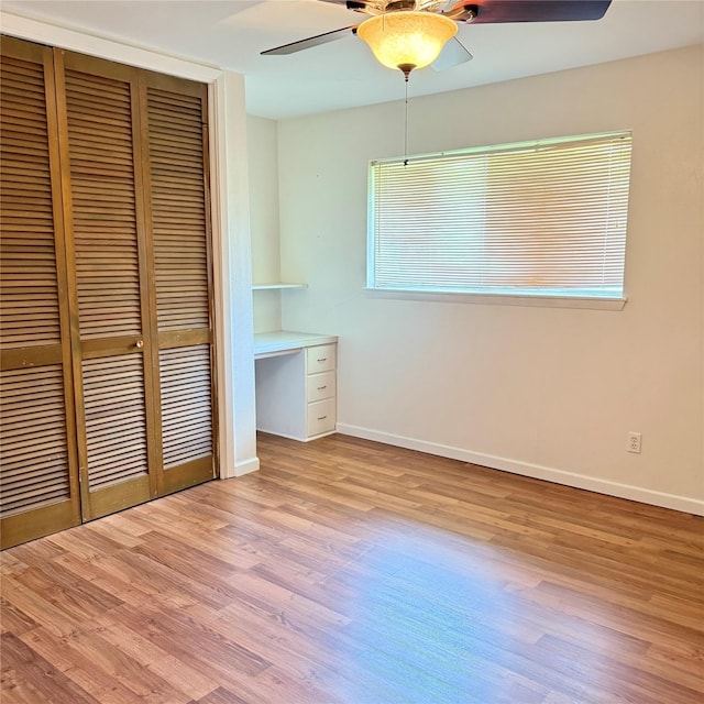 unfurnished bedroom with a closet, baseboards, and wood finished floors