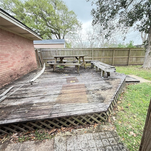 wooden terrace with outdoor dining area and a fenced backyard