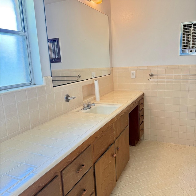 bathroom with tile patterned floors, tile walls, vanity, and a wainscoted wall