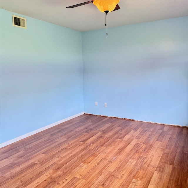 unfurnished room featuring light wood finished floors, baseboards, a ceiling fan, and visible vents
