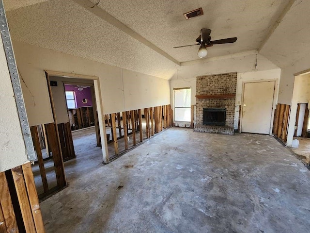 unfurnished living room with ceiling fan, a healthy amount of sunlight, lofted ceiling, and concrete floors