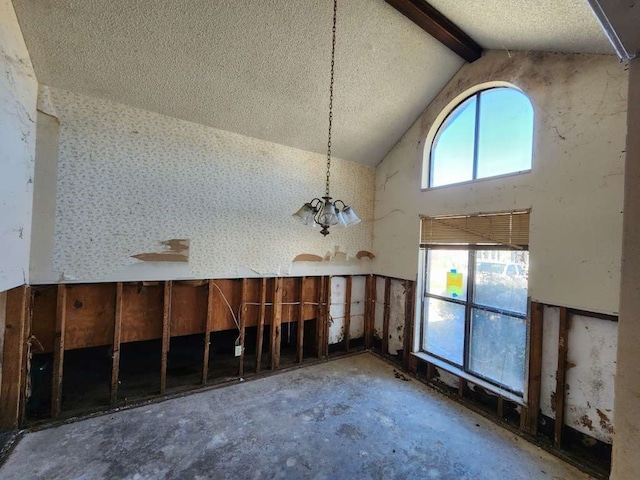 spare room with lofted ceiling with beams and a textured ceiling