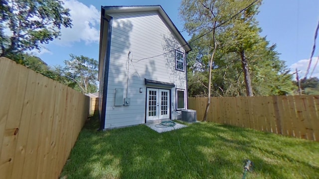 back of house with french doors, central AC, and a lawn