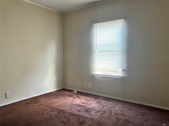 spare room with crown molding, a textured ceiling, and dark carpet