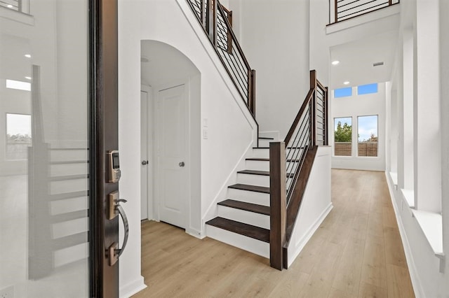 staircase featuring hardwood / wood-style floors and a high ceiling