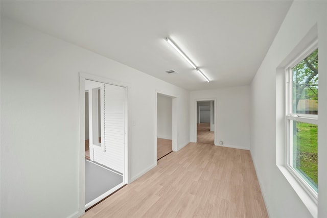 unfurnished room with plenty of natural light and light hardwood / wood-style flooring